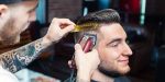 Peluquero profesional cortando el pelo de un cliente con una afeitadora con cable. Potentes y Resistentes.